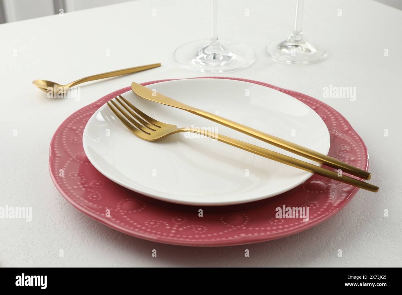 Stylish setting with cutlery and plates on white textured table Stock Photo