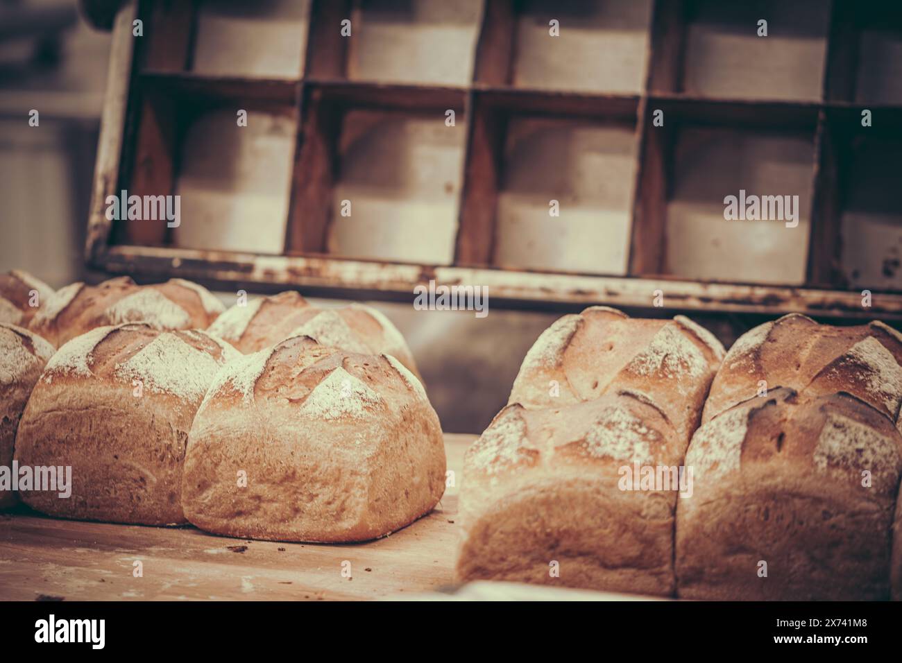 Freshly baked loaves of bread, baking pan in the back. Stock Photo