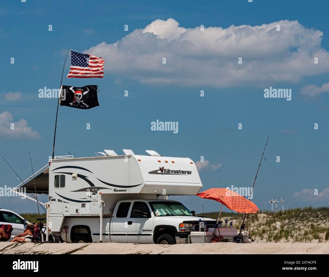 Robert Moses Beach, New York, USA - 14 July 2019: A camper is parked on the beach, with a flags flapping in the wind. Stock Photo