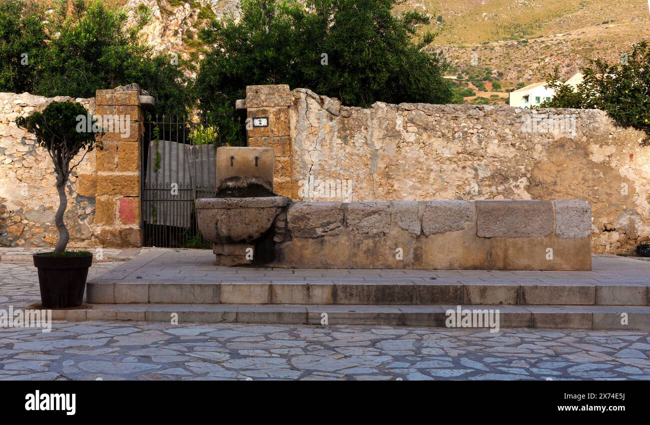 Old fountain in the main square of the little village of Scopello, Castellammare de Golfo in Sicily province of Trapani Stock Photo