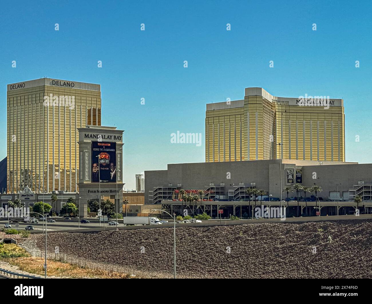Las Vegas, NV, USA - May 12, 2024: Delano and Mandalay Bay hotels, tall and golden facades under blue sky. Big Sign along Interstate 15 Stock Photo