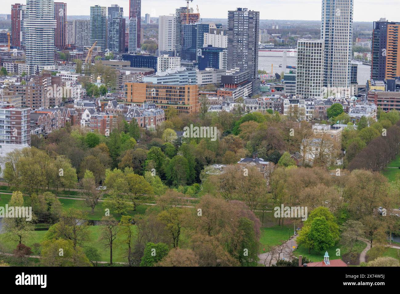 View of a mixture of modern skyscrapers and historic buildings with green areas, view from above of a modern city with skyscrapers, bridges and a Stock Photo