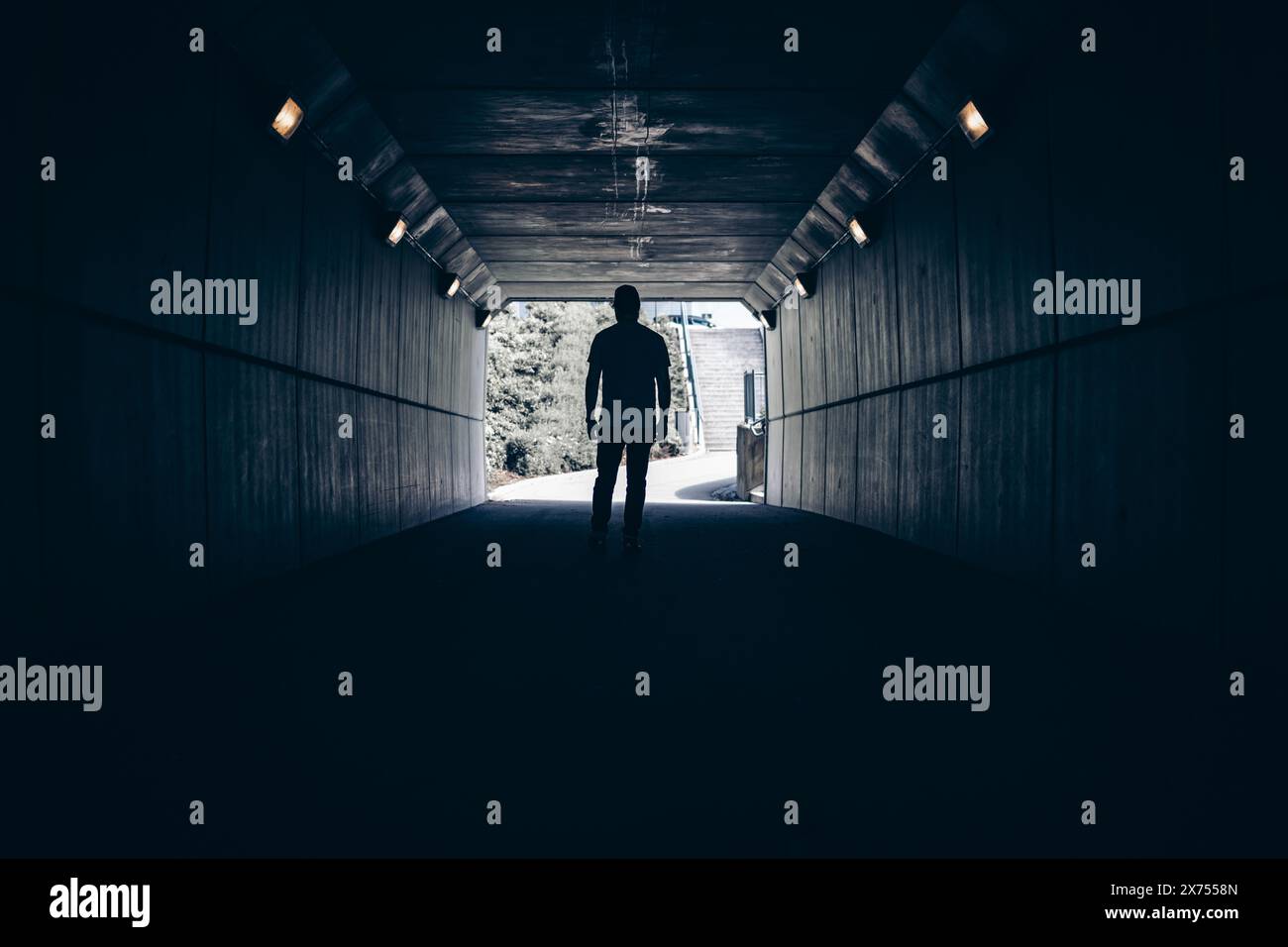A dark silhouette of a man standing in the middle of a tunnel Stock ...
