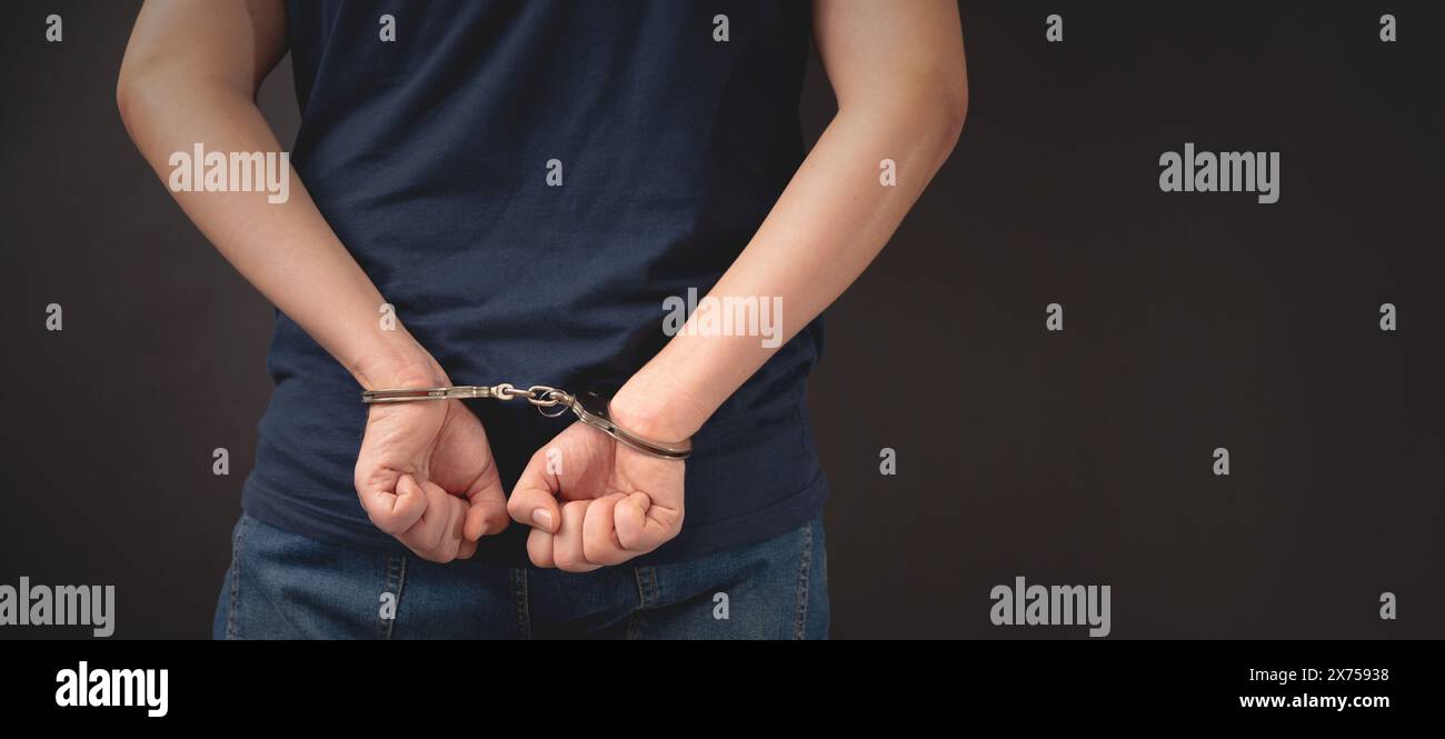 Arrested man in handcuffs with handcuffed hands behind back Stock Photo