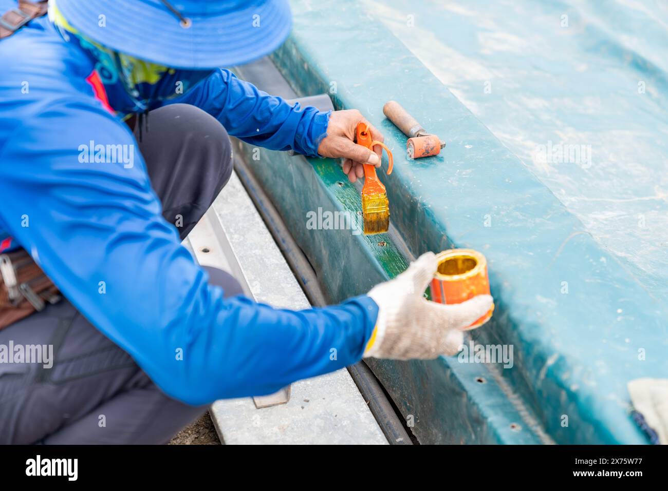 Worker apply rubber adhesive on plastic canvas for gasket edge of waste water dome. Stock Photo