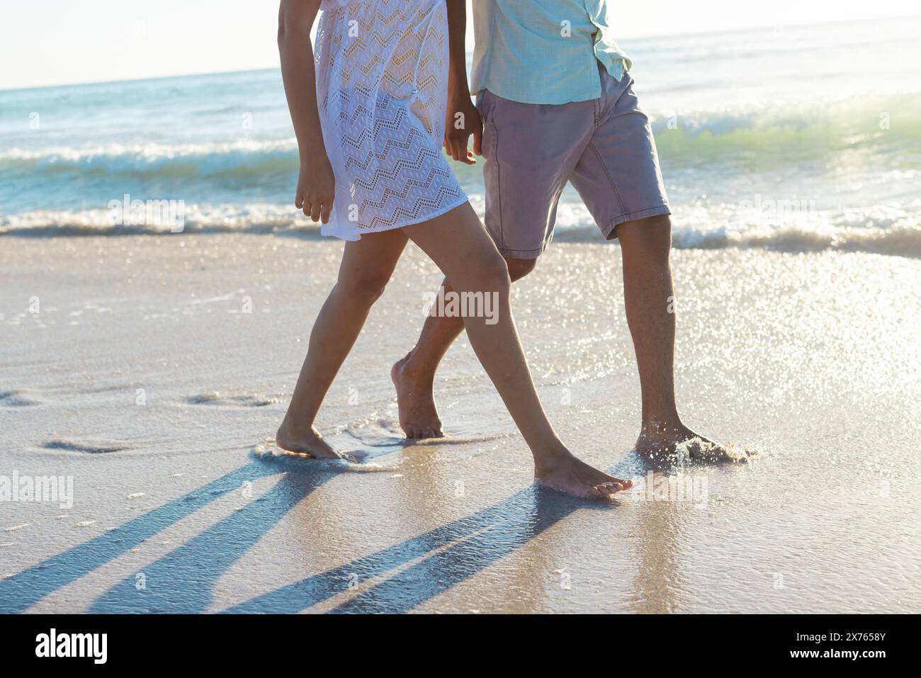 At beach, biracial couple walking barefoot, waves touching feet Stock ...