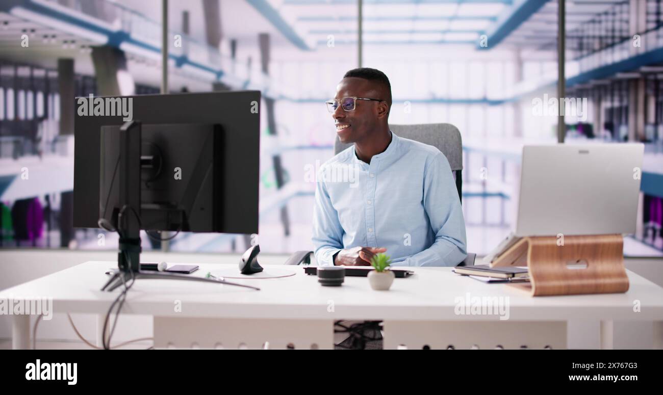 Employee Working On Desktop Computer In Home Office Stock Photo