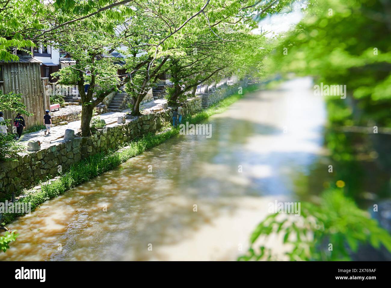 Tourists strolling along the canal in the historic village of Omihachiman in Japan Stock Photo