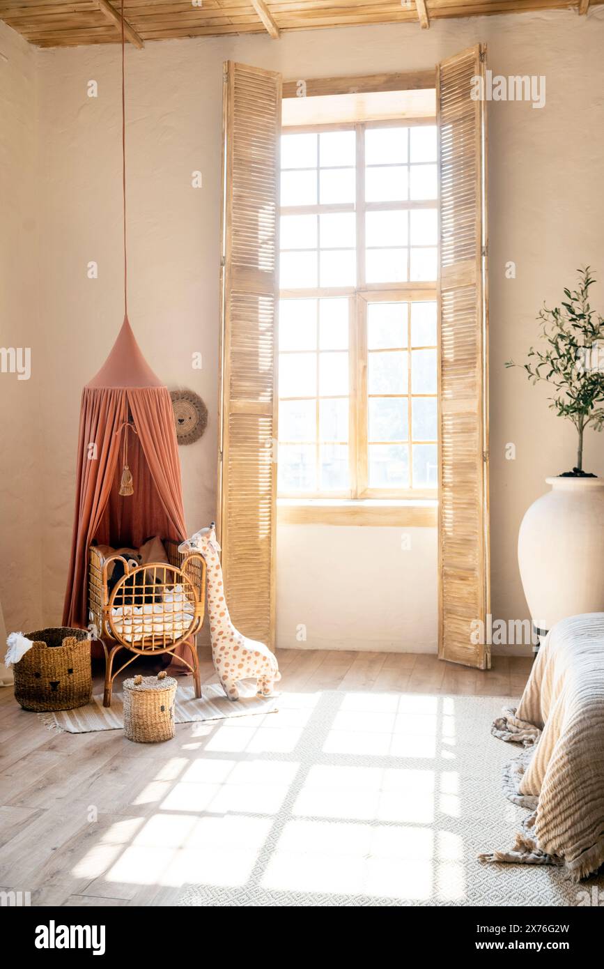 children's room in Scandinavian style, light with bed, toys and a large window with sunlight. wooden furniture . Stock Photo