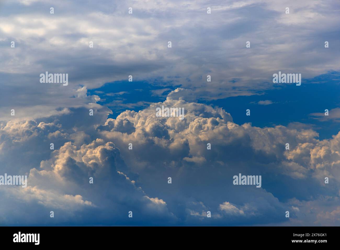 Large cumulus clouds building with a patch of blue sky Stock Photo