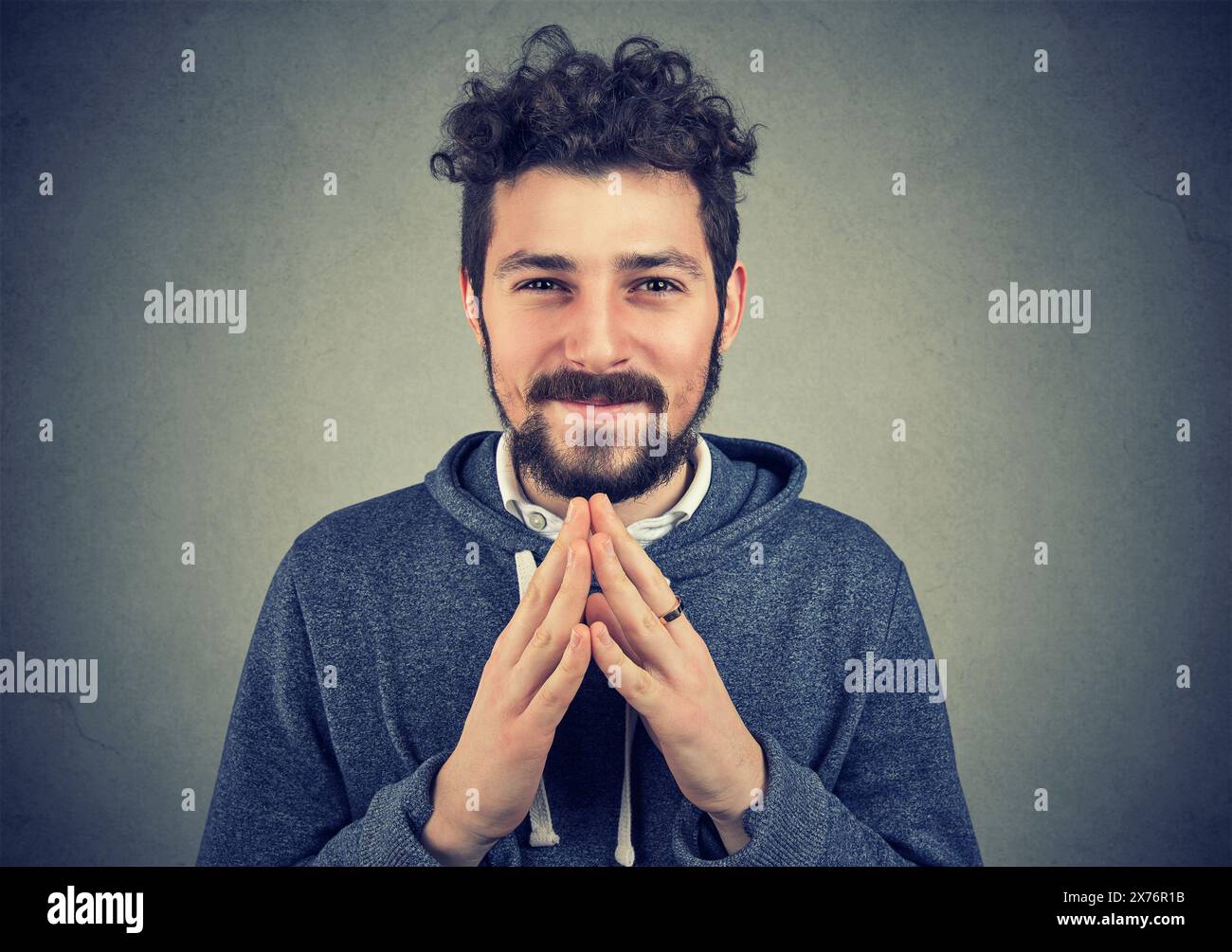 Cunning man clasping hands and planning evil tricky prank or scheming