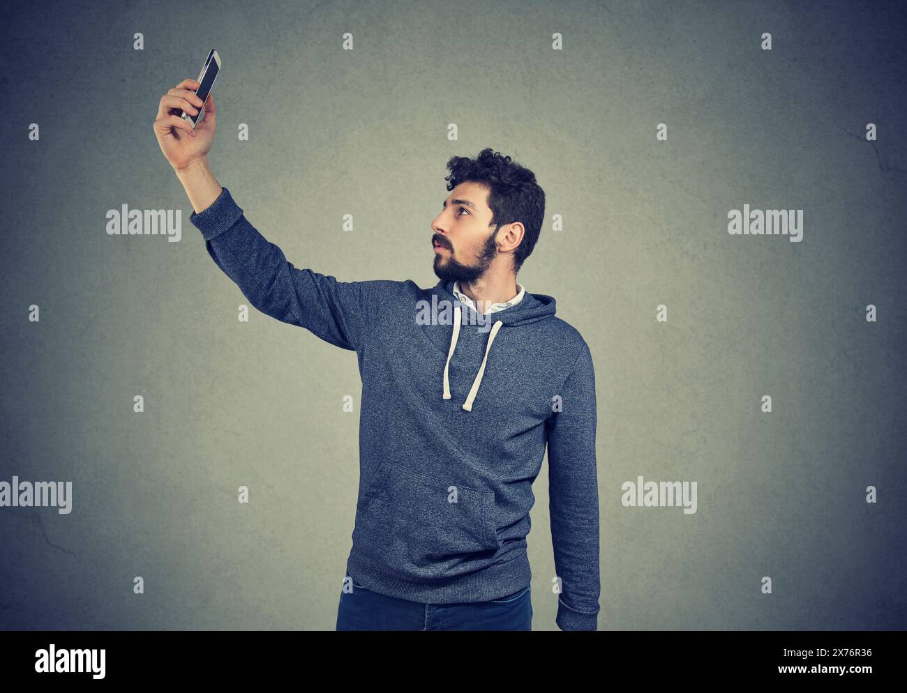 Bad wifi connection, man lifts mobile phone up and wants to connect to internet. Stock Photo