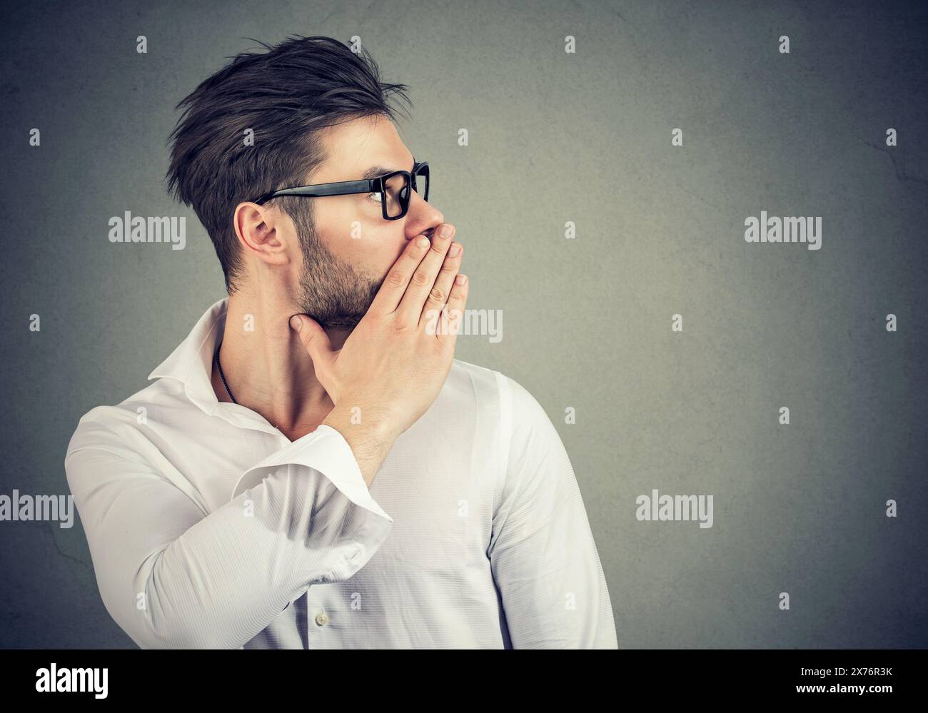 Young man whispering to the side Stock Photo