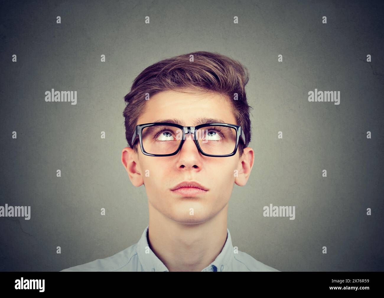Portrait of a thinking young man looking up Stock Photo