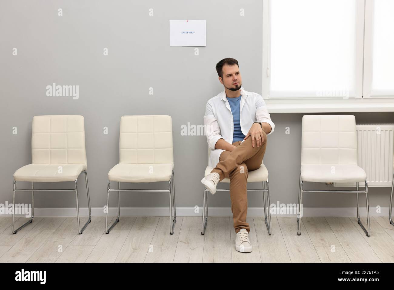 Man sitting on chair and waiting for job interview indoors Stock Photo