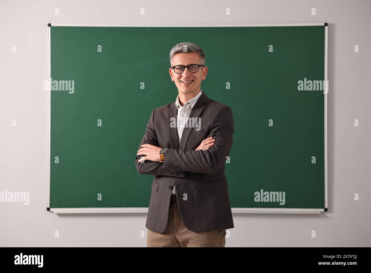 Teacher in glasses near chalkboard in classroom Stock Photo - Alamy