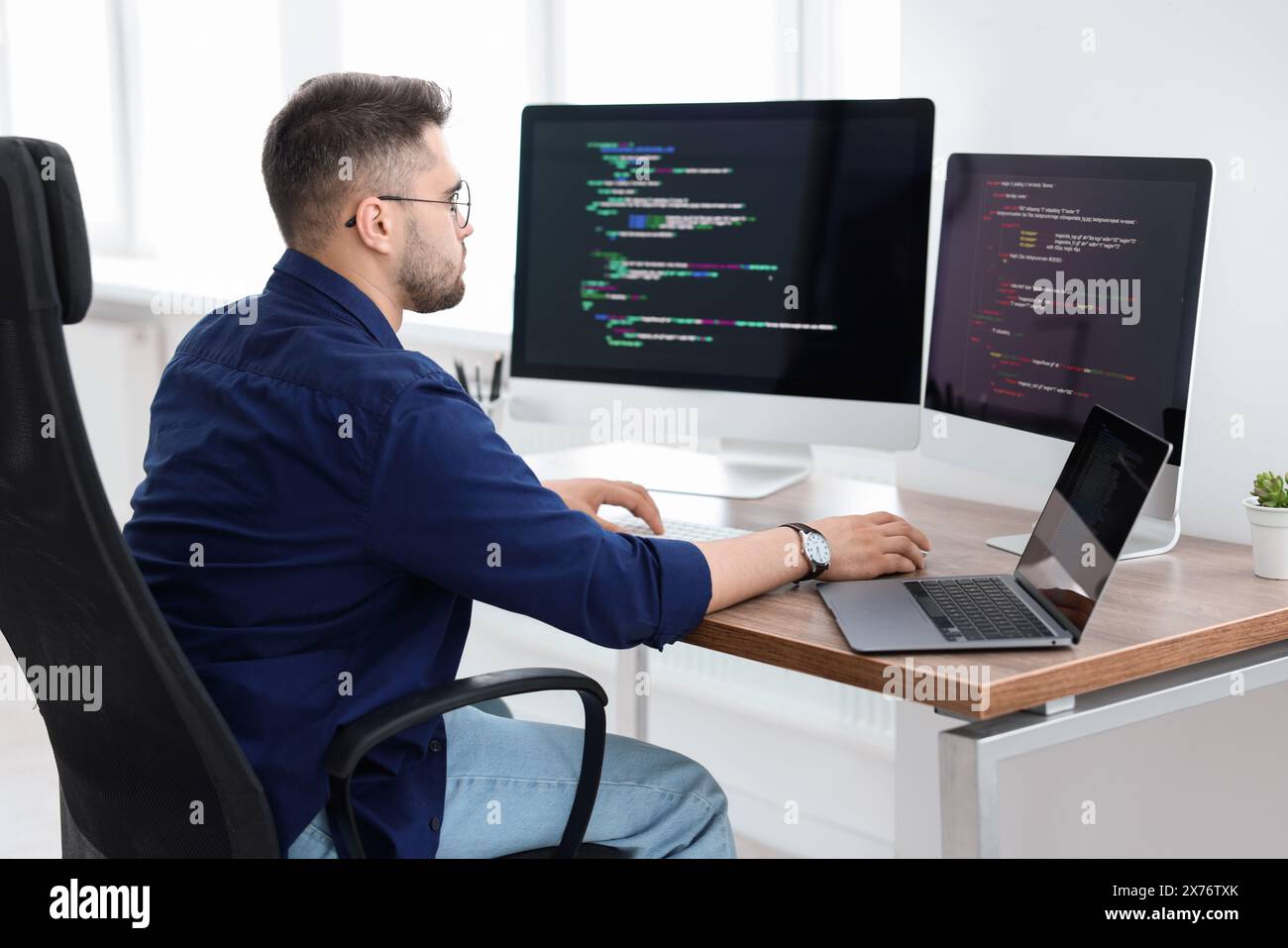 Young programmer working at desk in office Stock Photo