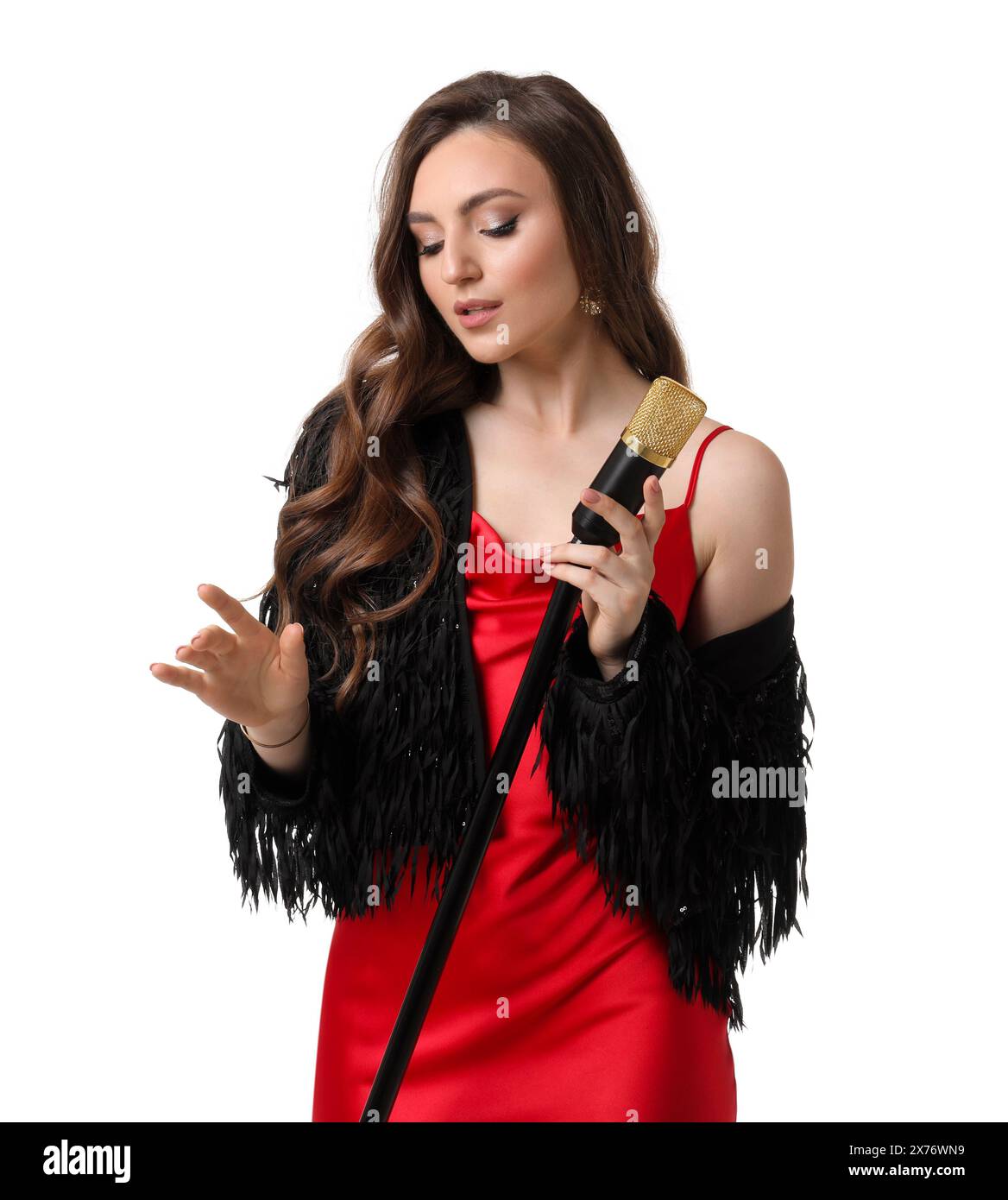 Beautiful young woman in stylish red dress with microphone singing on ...
