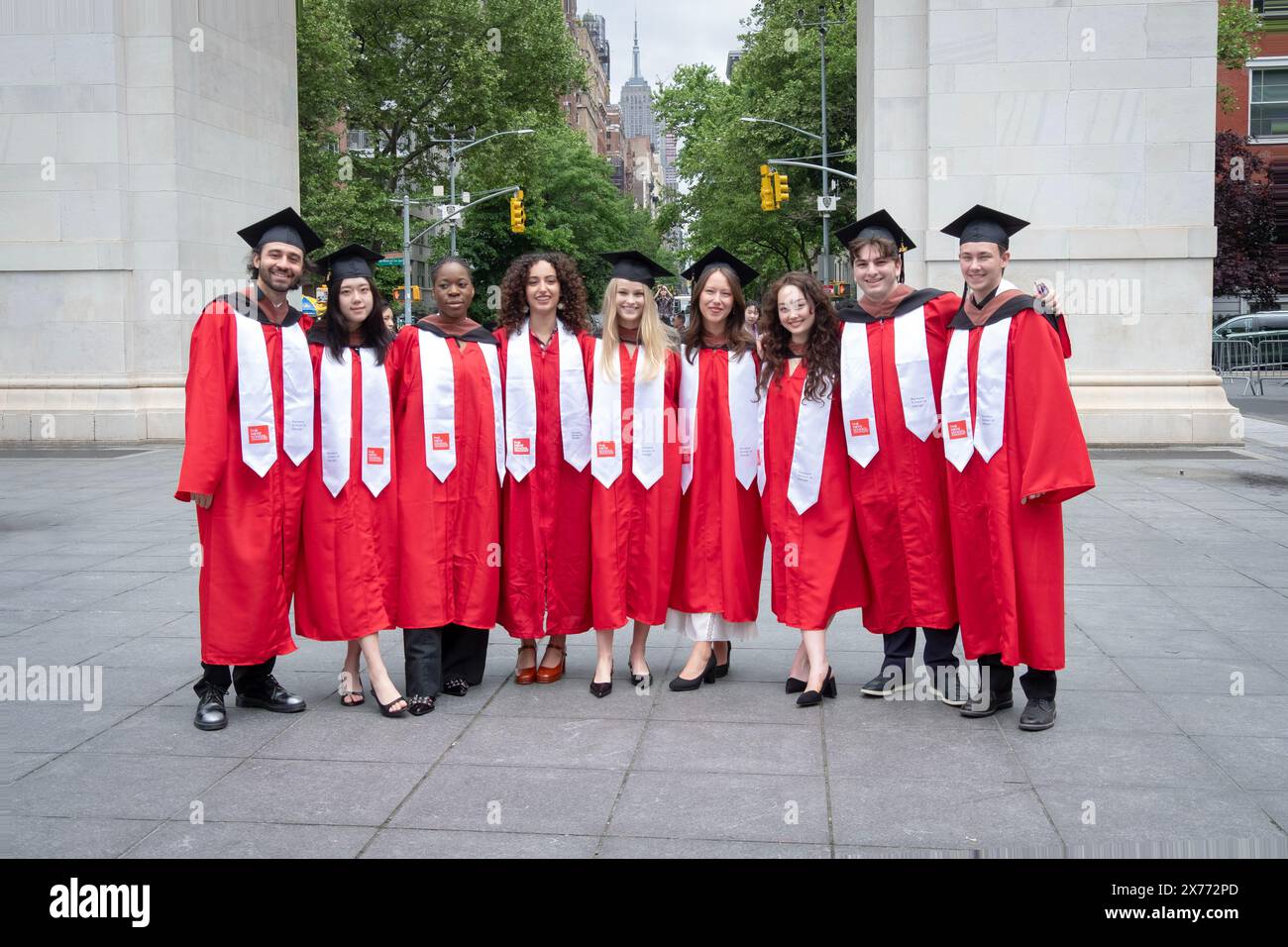 Graduates from the New School, Parsons School of Design pose in their caps & red gowns near the arch in Washington Square Park in Manhattan. Stock Photo