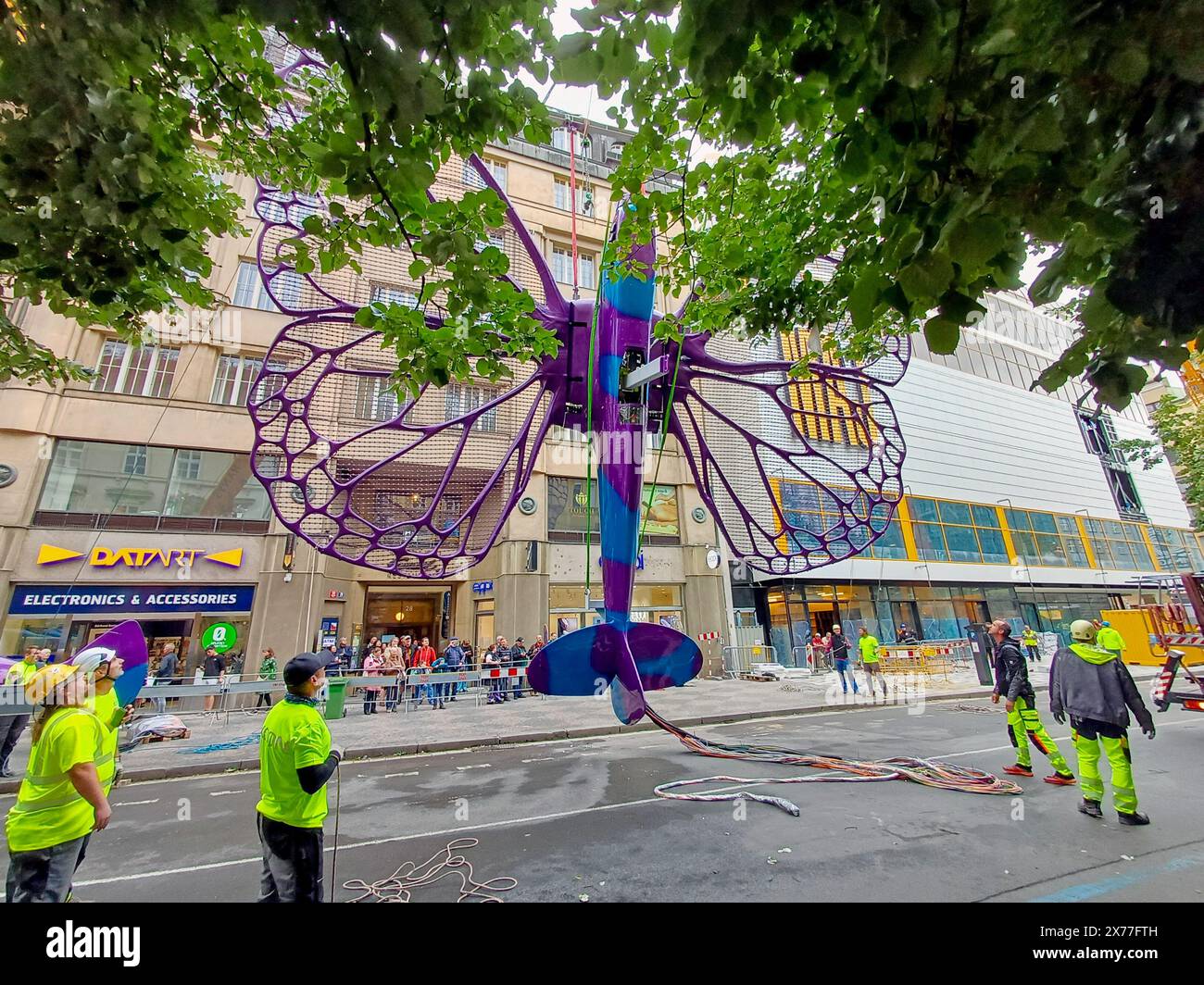 Prague, Czech Republic. 18th May, 2024. Installation of artworks on the facade of renovated Maj department store has begun on 18 May 2024, Prague, Czech Republic. The author of two several-metre-long moving sculptures of butterflies, whose fuselages are imitations of spitfire fighters, is Czech artist David Cerny. They are to become a tribute to Czechoslovak pilots who fought in the Second World War. The civic association Klub za starou Prahu (Club for Old Prague) disagrees with the placement, saying it is typical kitsch. Credit: Ales Berny/CTK Photo/Alamy Live News Stock Photo