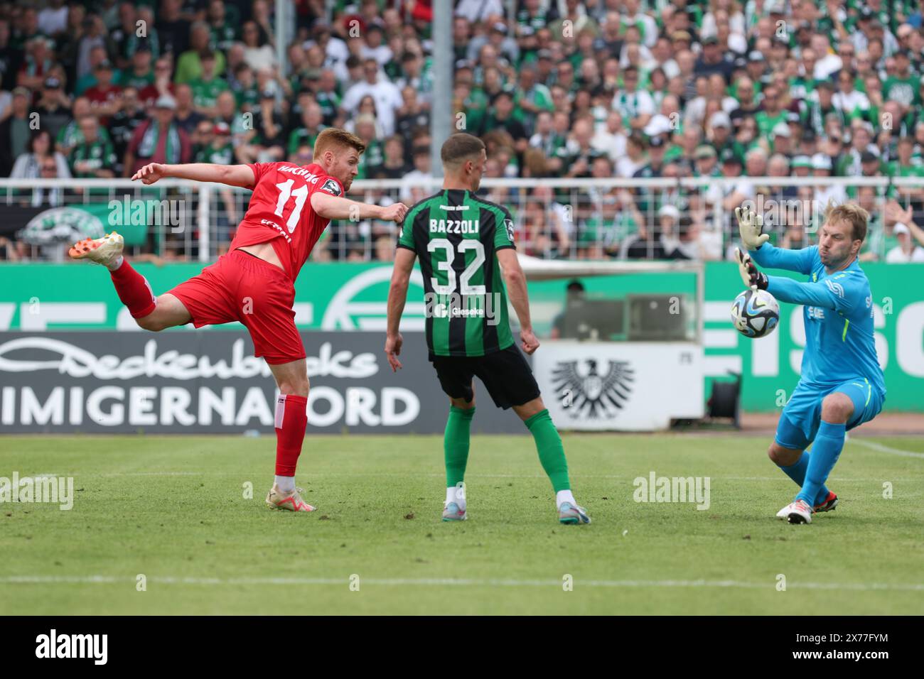 18 May 2024, North Rhine-Westphalia, Münster: Soccer: 3rd division, Preußen Münster - SpVgg Unterhaching, matchday 38, at the Preußenstadion. Münster's Luca Bazzoli (center) and goalkeeper Maximilian Schulze-Niehues (right) watch as Unterhaching's Mathias Fetsch (left) heads the ball into the goal. The goal is later disallowed. Photo: Friso Gentsch/dpa Stock Photo