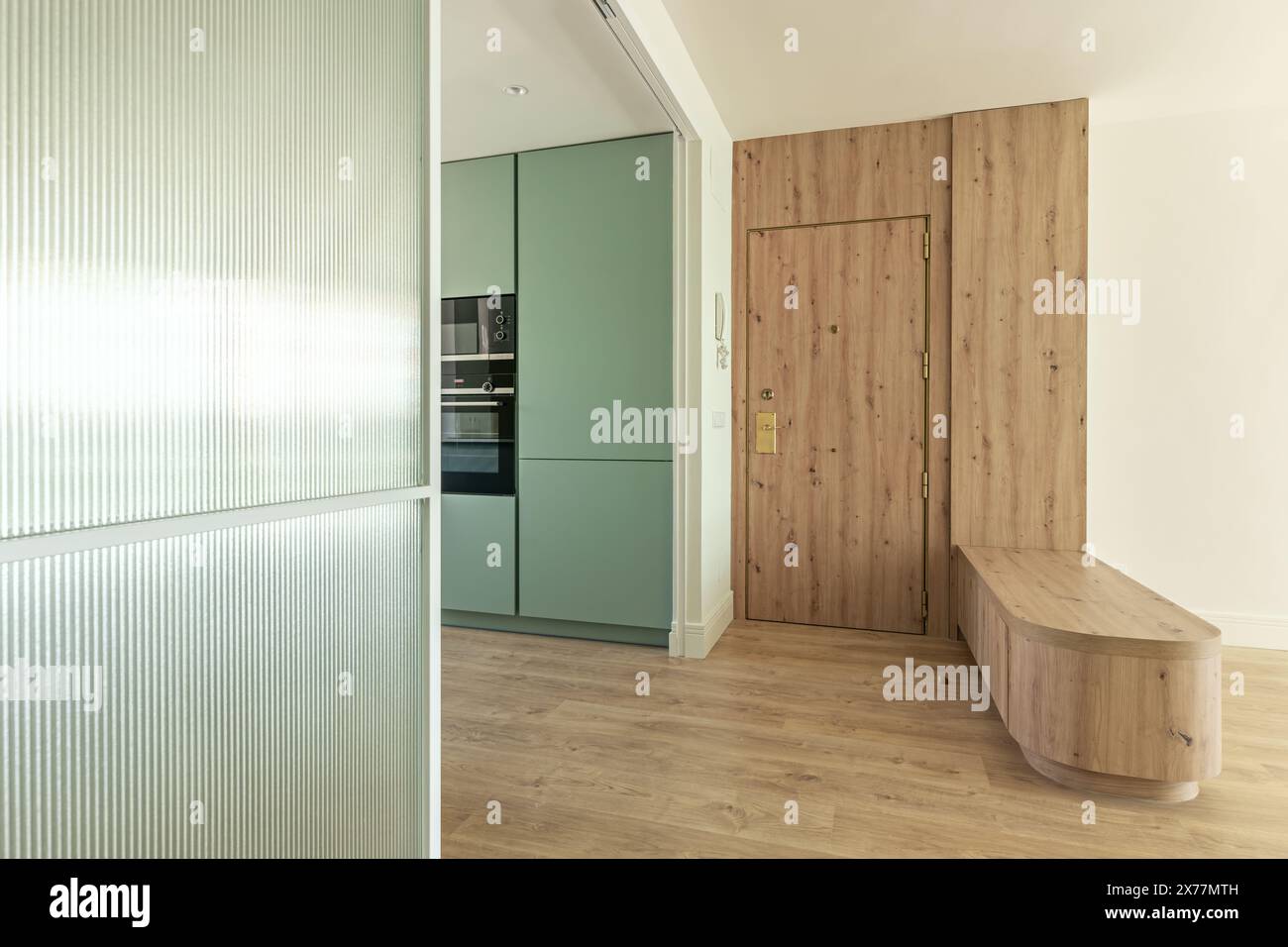 Frontal image of an open kitchen with a modern design with pastel green ...