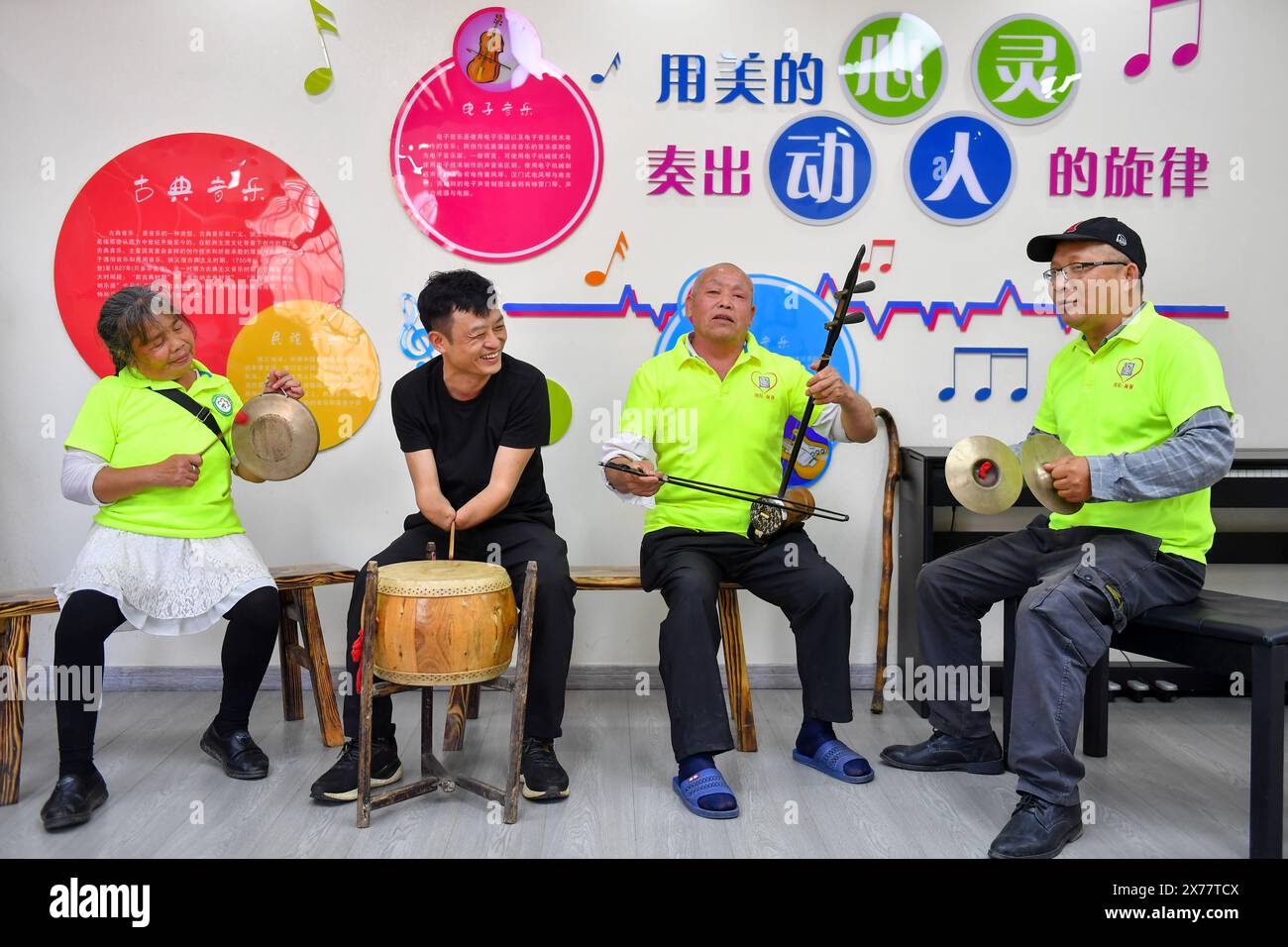 (240518) -- CHANGSHA, May 18, 2024 (Xinhua) -- Lin Mingchang (2nd L) and other disabled people practice musical instruments at a service center for the disabled in Dayao Township of Liuyang City, central China's Hunan Province, May 15, 2024.  Lin Mingchang, born in 1982, lost both of his hands in a car accident when he was 22 years old. Despite grappling with despair in the aftermath, he mustered up the courage to rebuild his life.   Lin started his printing business with a computer and a printer. The beginning was very hard for him. He spent much more time than a normal person mastering typin Stock Photo