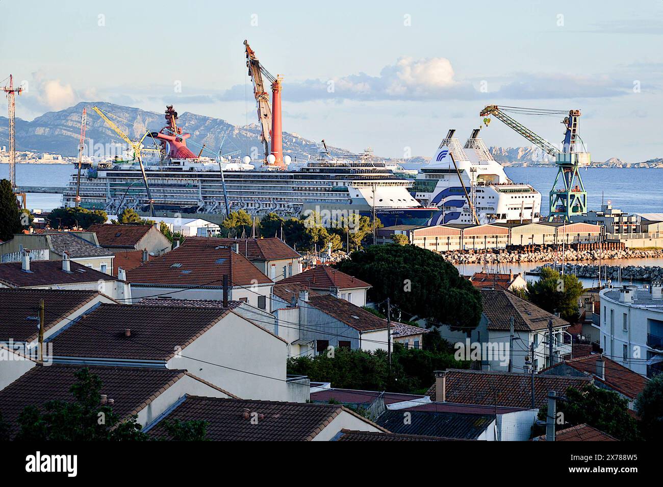 The cruise ship Carnival Legend, the Pipelay Crane Vessel (PCV) Saipem Constellation and the ocean liner Rhapsody are seen docked in 'Form 10' for maintenance and repairs. “Form 10” is the largest basin on the naval site of the Grand Port Maritime de Marseille (GPMM). It is the largest form of refit in the Mediterranean. Stock Photo
