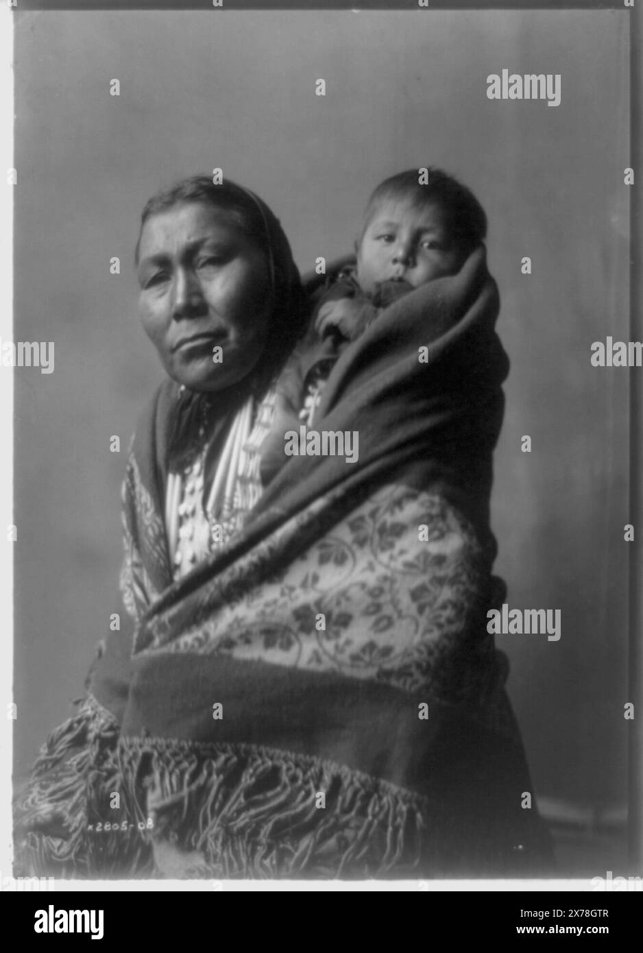 Hidatsa mother, 'Mrs. Good Bear' on verso., No. 2805-08., Published in: The North American Indian / Edward S. Curtis. [Seattle, Wash.] : Edward S. Curtis, 1907-30, suppl. v. 4, p. 142.. Indians of North America, Women, 1900-1910. , Hidatsa Indians, 1900-1910. , Mothers & children, 1900-1910. Stock Photo