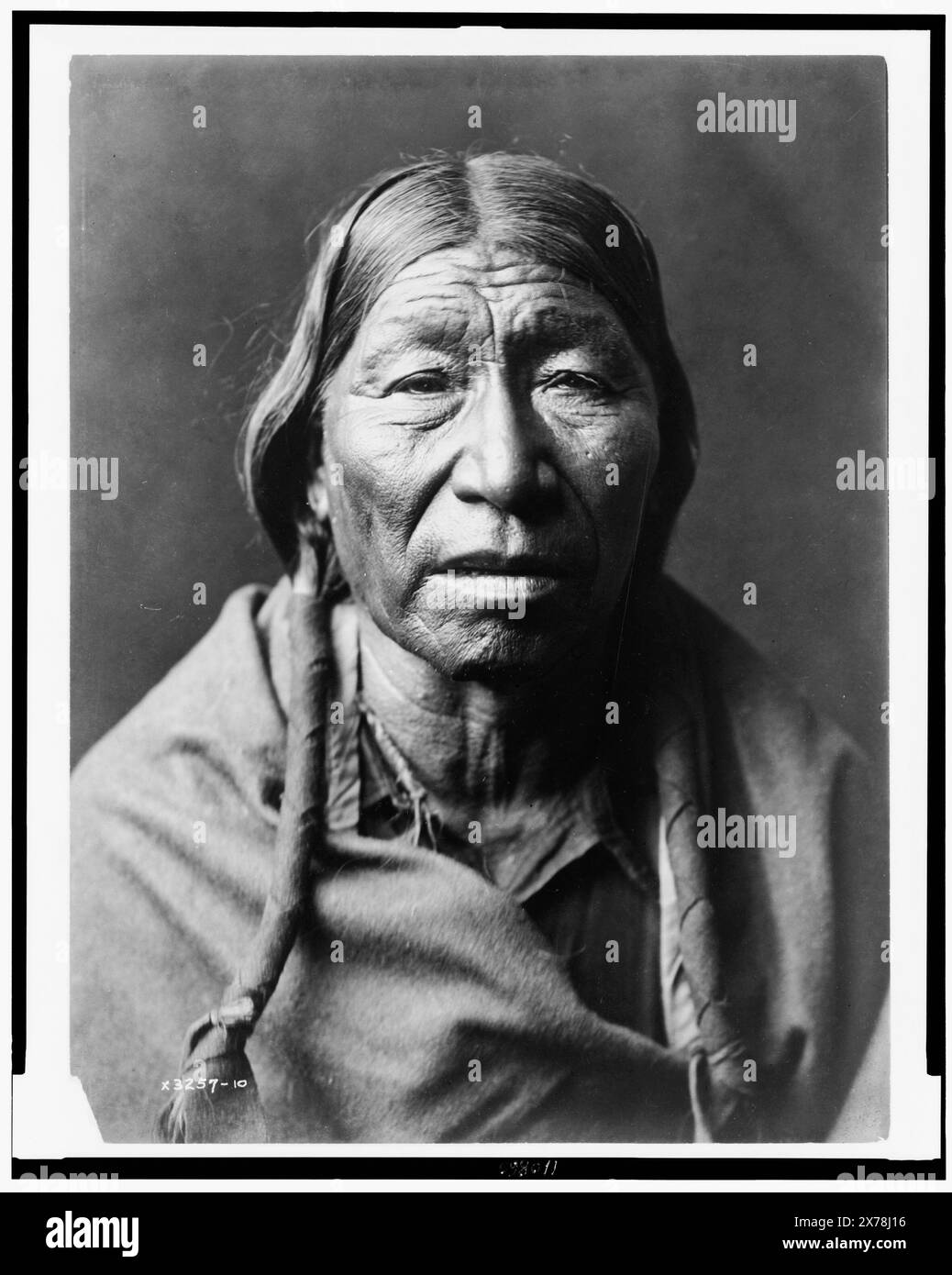 Cheyenne male, facing front, hair in wrapped braids, blanket around shoulders, Edward S. Curtis Collection., Curtis no. 3257-10., Published in: The North American Indian / Edward S. Curtis. [Seattle, Wash.] : Edward S. Curtis, 1907-30, suppl., v. 6, p. 210.. Indians of North America, 1910. , Cheyenne Indians, 1910. Stock Photo