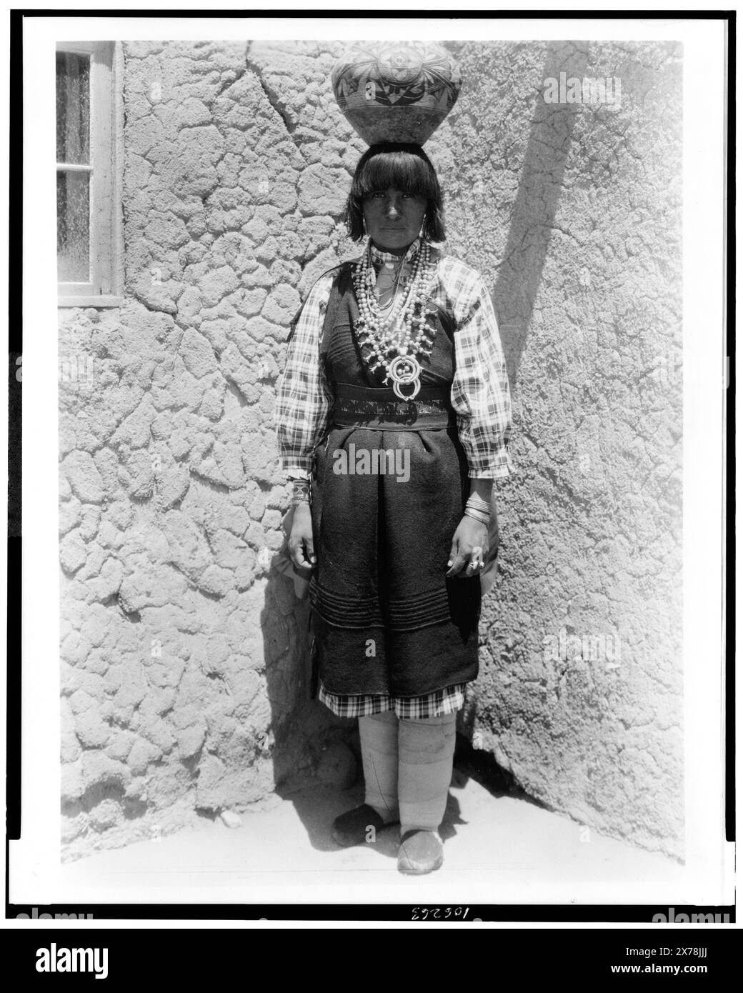 Shuati Sia. Full-length portrait of a woman standing, facing front, with pot on head, Edward S. Curtis Collection., Published in: The North American Indian / Edward S. Curtis. [Seattle, Wash.] : Edward S. Curtis, 1907-30 suppl., v. 16, p. 561.. Indians of North America, Clothing & dress, 1920-1930. , Sia Indians, Clothing & dress, 1920-1930. Stock Photo