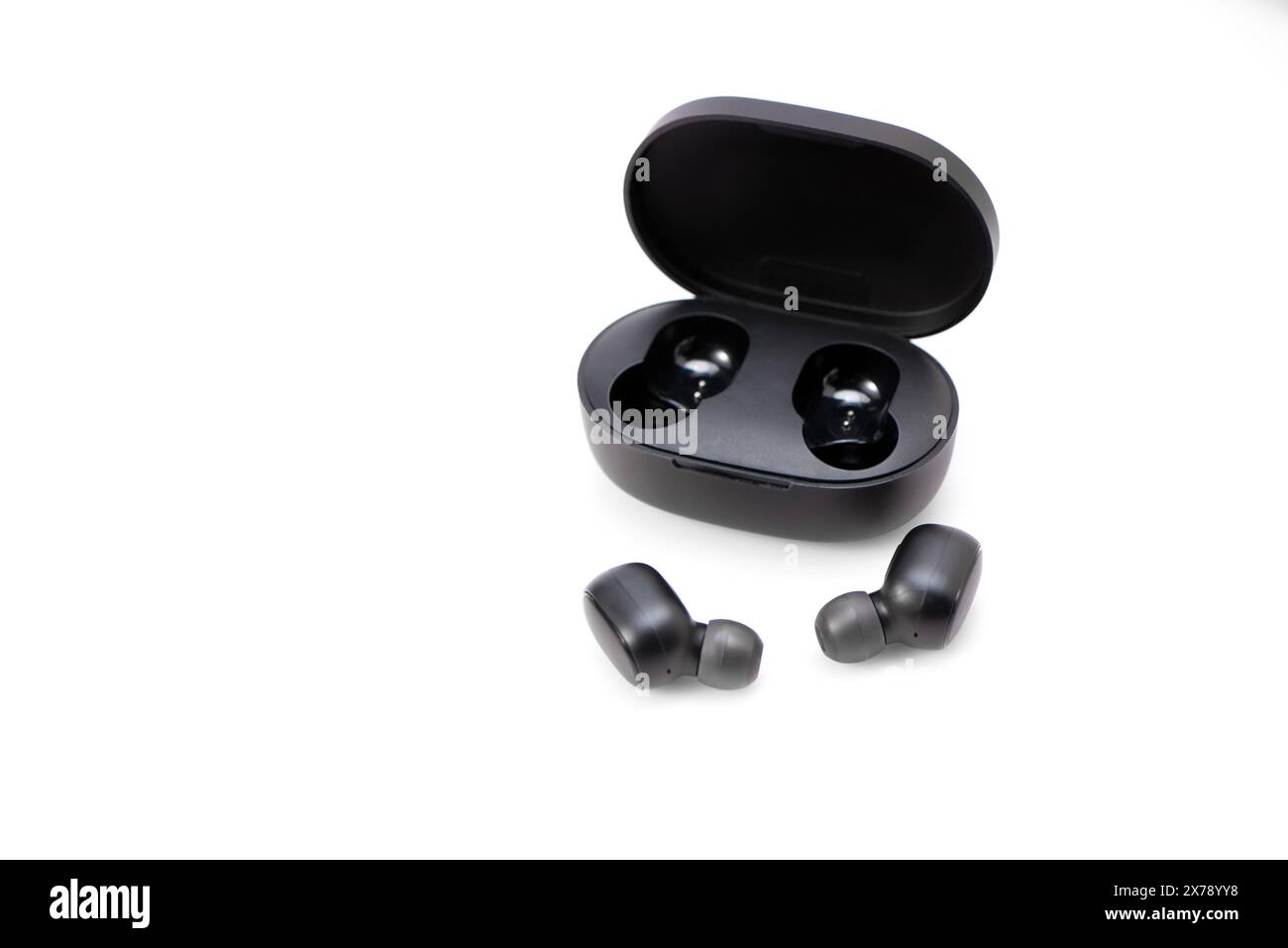 Wireless headphones isolated on a white background. Headset close up in the charging case close-up Stock Photo