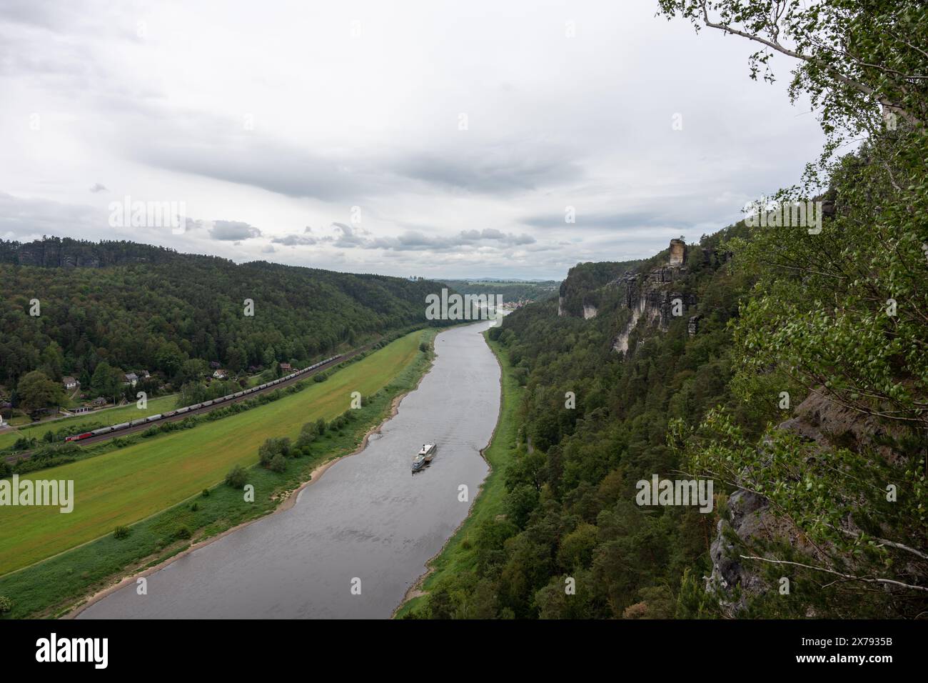 A river with a boat on it and a cloudy sky in the background Stock Photo