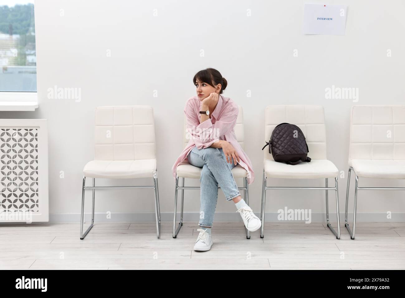 Woman sitting on chair and waiting for job interview indoors Stock Photo
