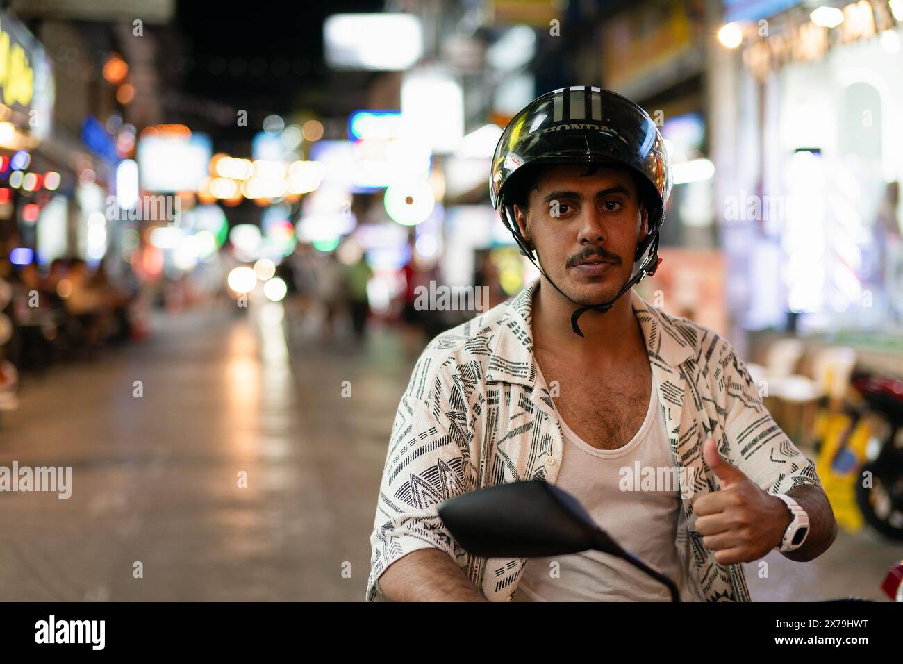PHUKET, THAILAND - APRIL 25, 2023: a man riding a motorbike in Patong, Phuket. Stock Photo