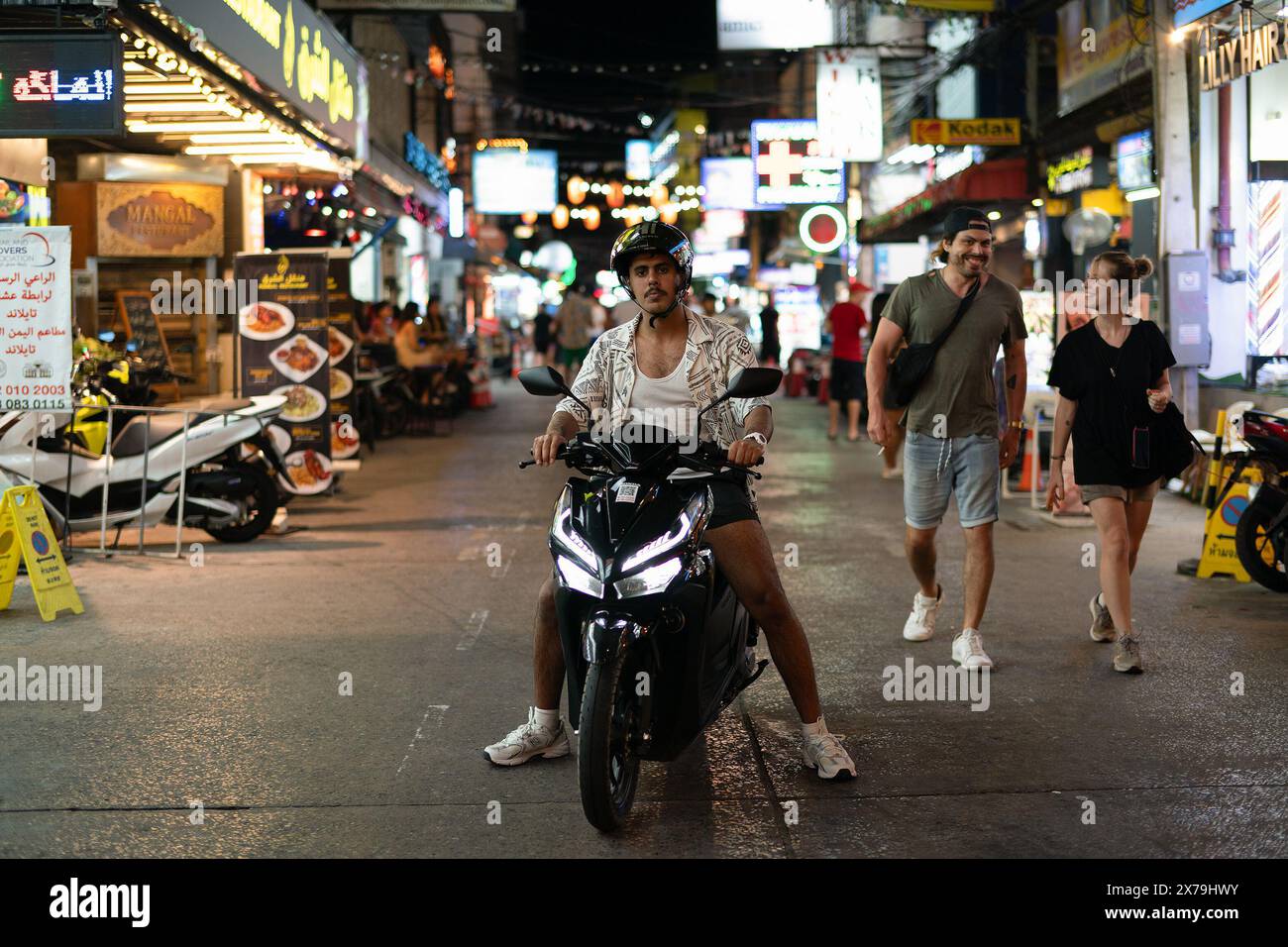 PHUKET, THAILAND - APRIL 25, 2023: a man riding a motorbike in Patong, Phuket. Stock Photo