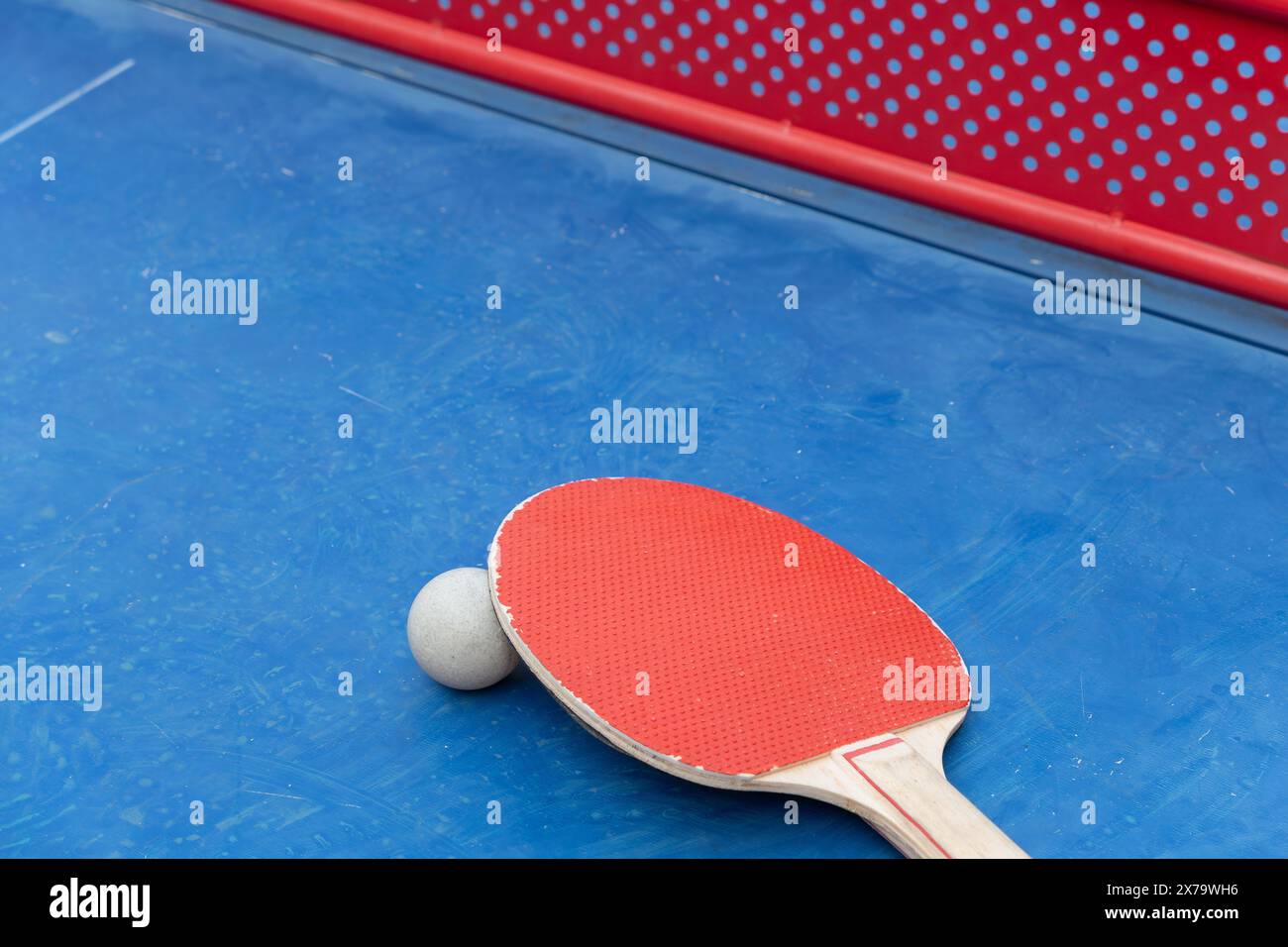 angle view pingpong racket and ball and net on a blue pingpong table at horizontal composition Stock Photo