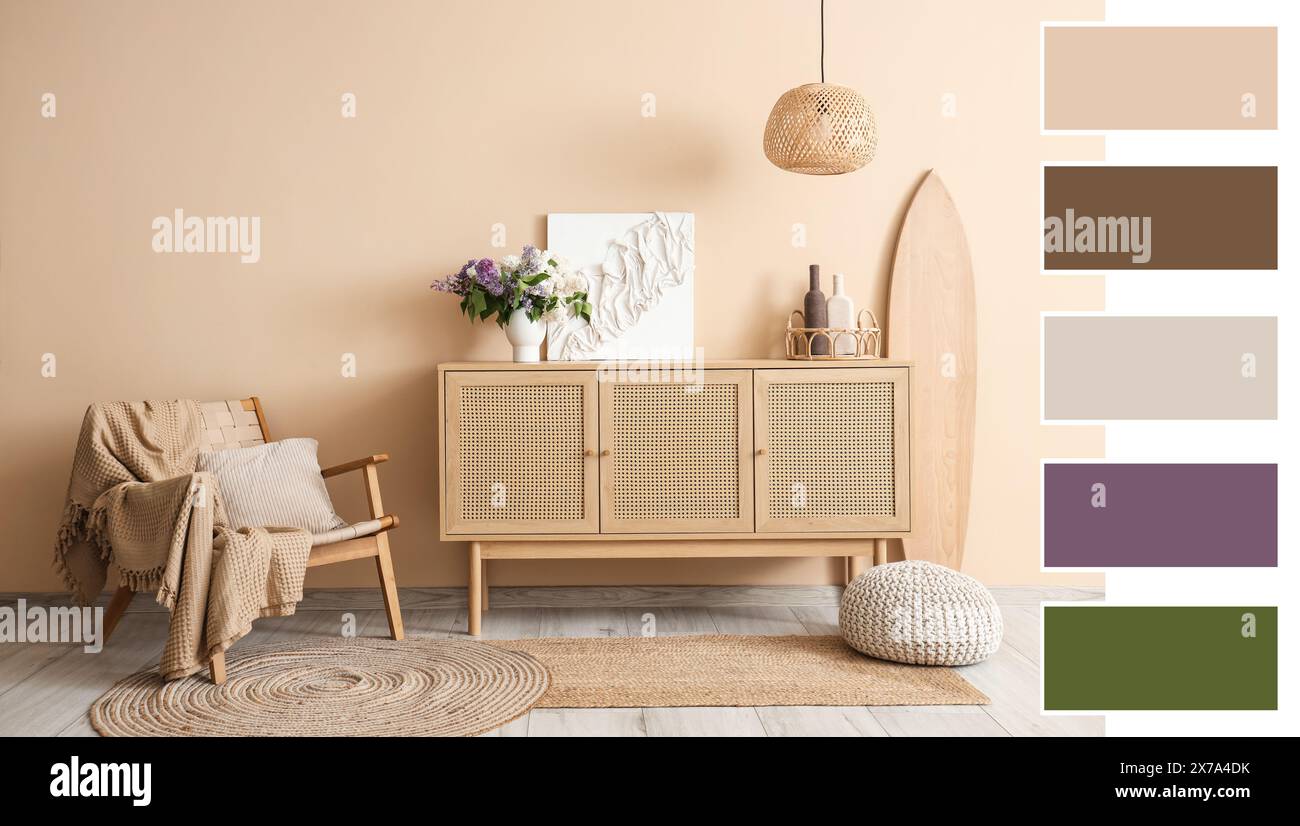 Wooden chest of drawers, surfboard and armchair near beige wall in room ...