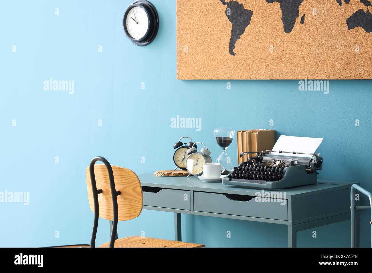 Vintage typewriter with coffee cup, alarm clocks and books on table in office Stock Photo