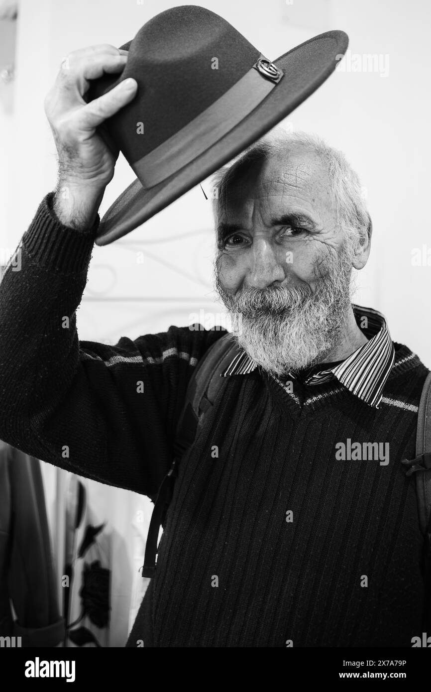 Bearded Old Man in a Hat. An old traveler with a backpack and a ...