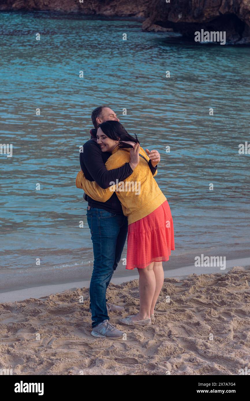 A couple in love hugs on the sea beach. A man and a woman enjoy each other and their vacation by the sea. Stock Photo