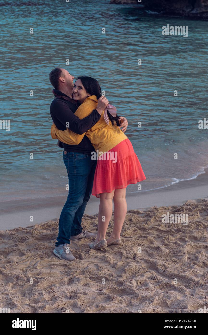 A couple in love hugs on the sea beach. A man and a woman enjoy each other and their vacation by the sea. Stock Photo