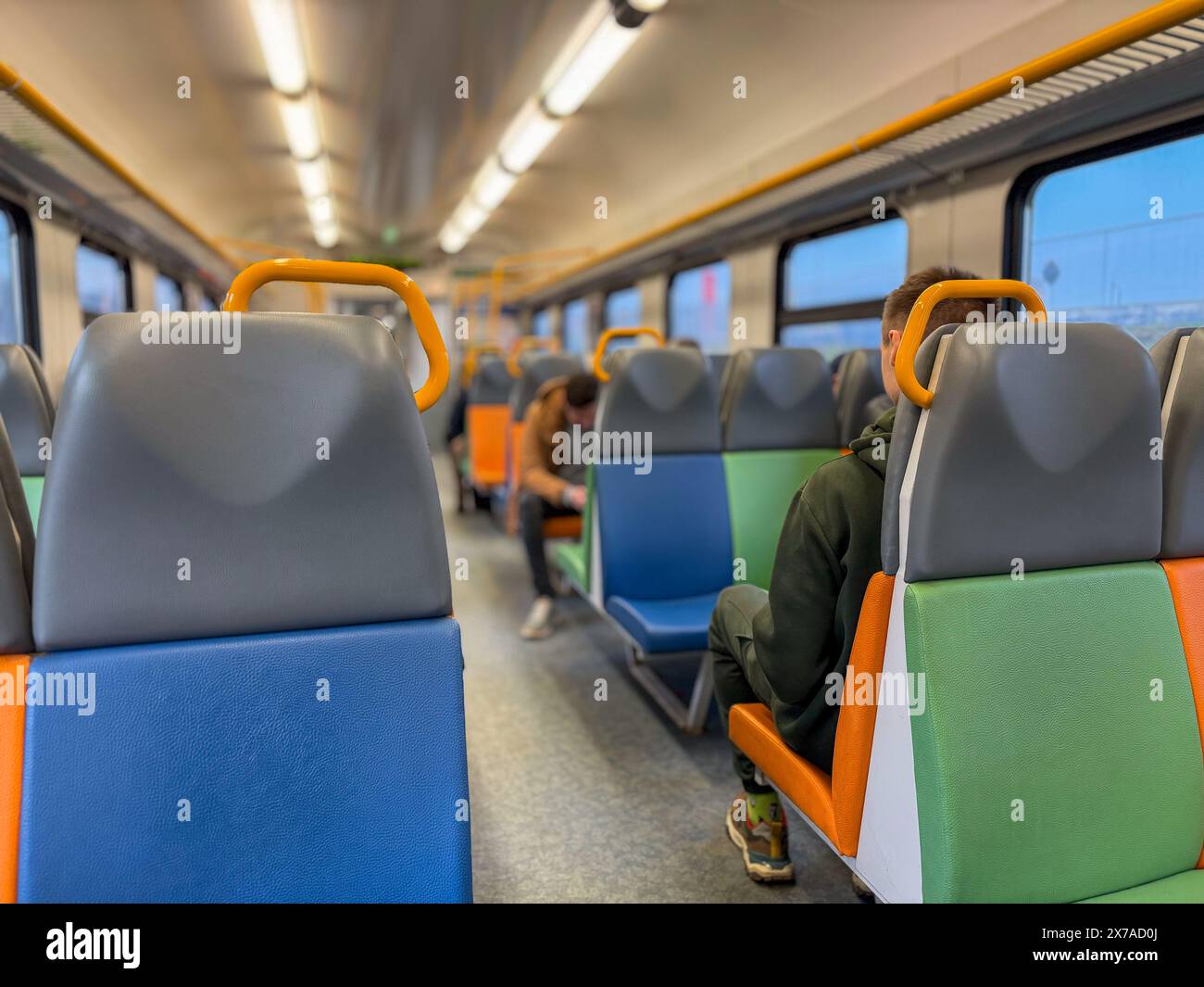 Interior of a modern train with empty seats and passengers sitting ...