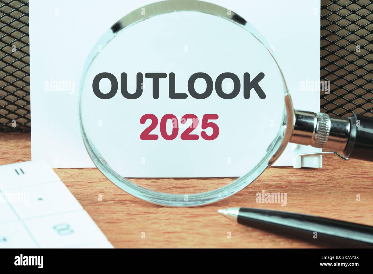 Business and financial trends. OUTLOOK 2025 text through a magnifying