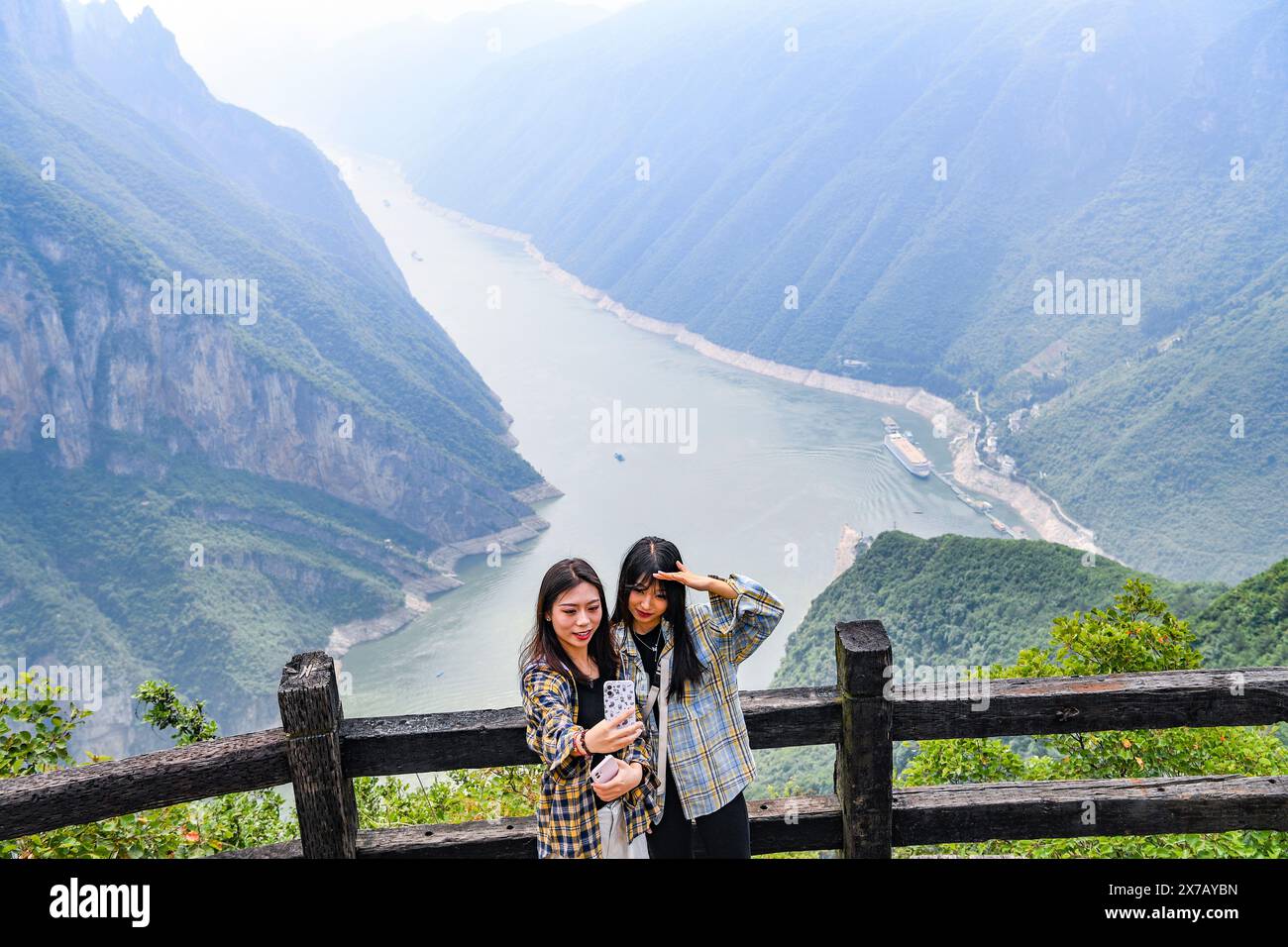Chongqing, China's Chongqing Municipality. 16th May, 2024. Tourists pose for photos at a scenic area in Wushan County, southwest China's Chongqing Municipality, May 16, 2024. In recent years, taking cultural tourism industry as its strategic pillar industry, Wushan County has been promoting tourism centering on Three Gorges area. Multiple measures have also been implemented including establishing innovative tourism projects, improving tourism infrastructure to boost the high-quality development of tourism. Credit: Wang Quanchao/Xinhua/Alamy Live News Stock Photo