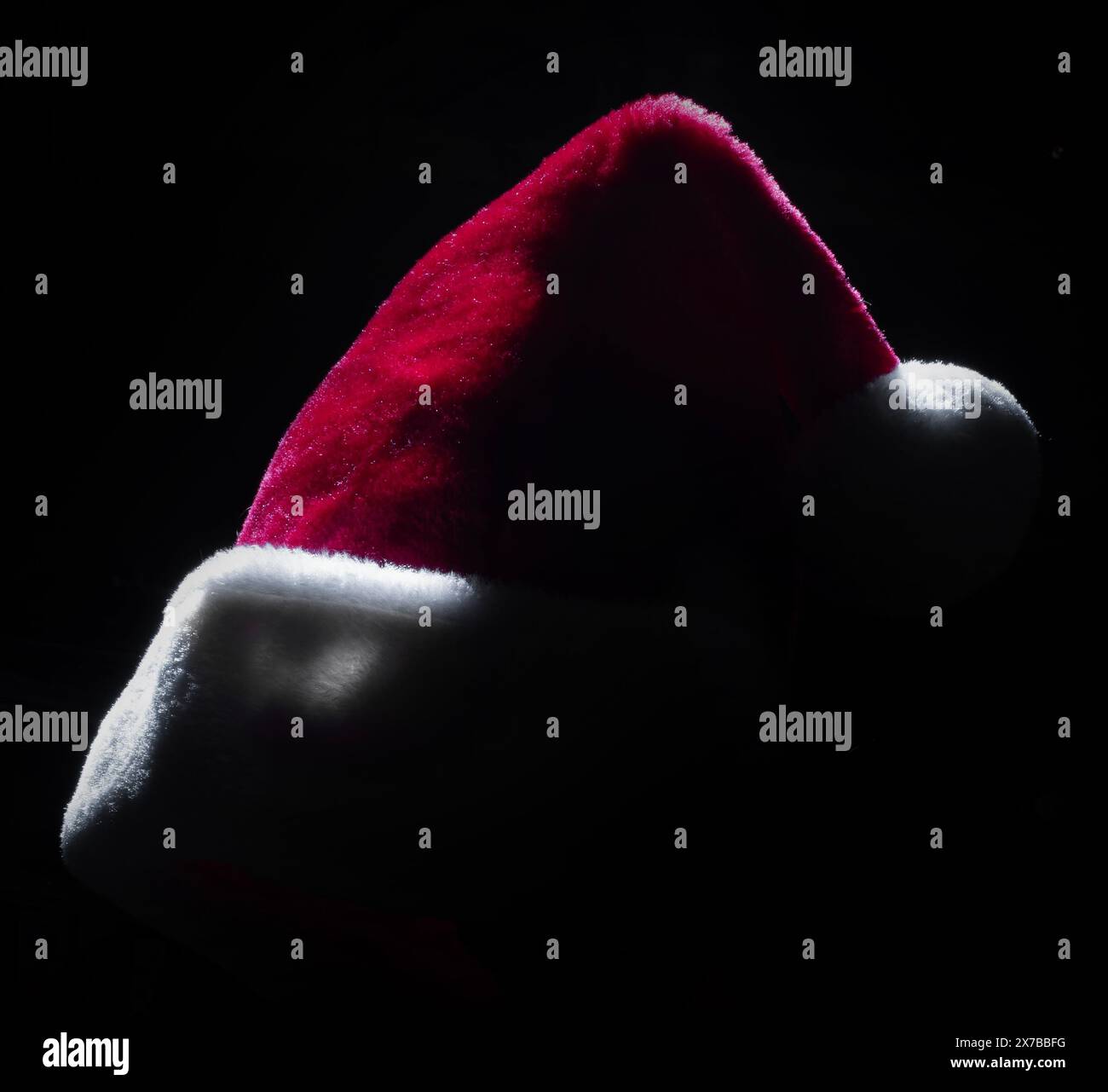 Side lighted red hat usually worn by Santa Claus on a black background ...