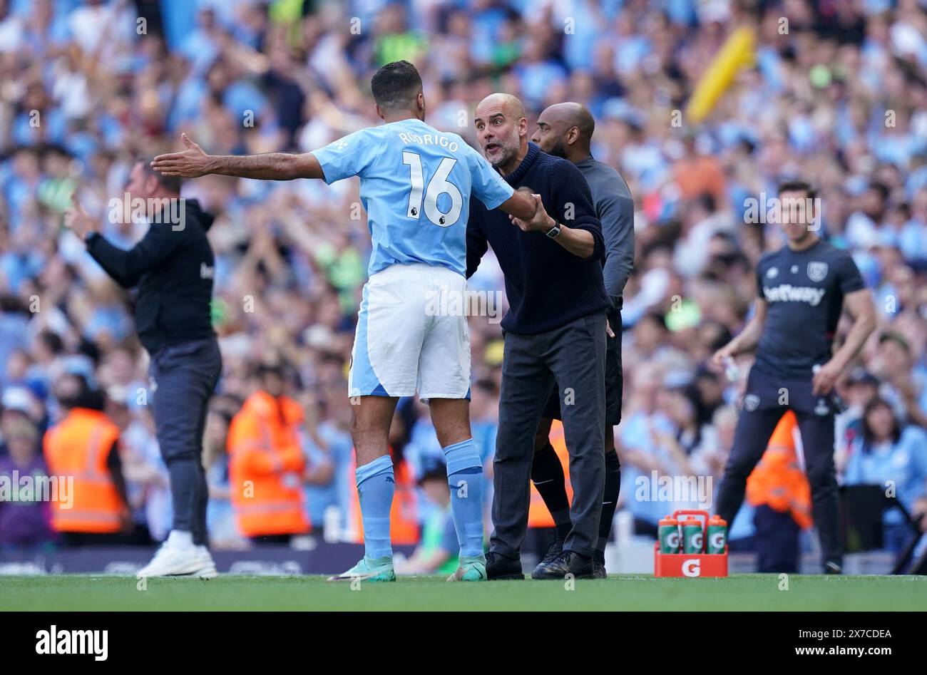Manchester City manager Pep Guardiola speaks to Rodri on the touchline