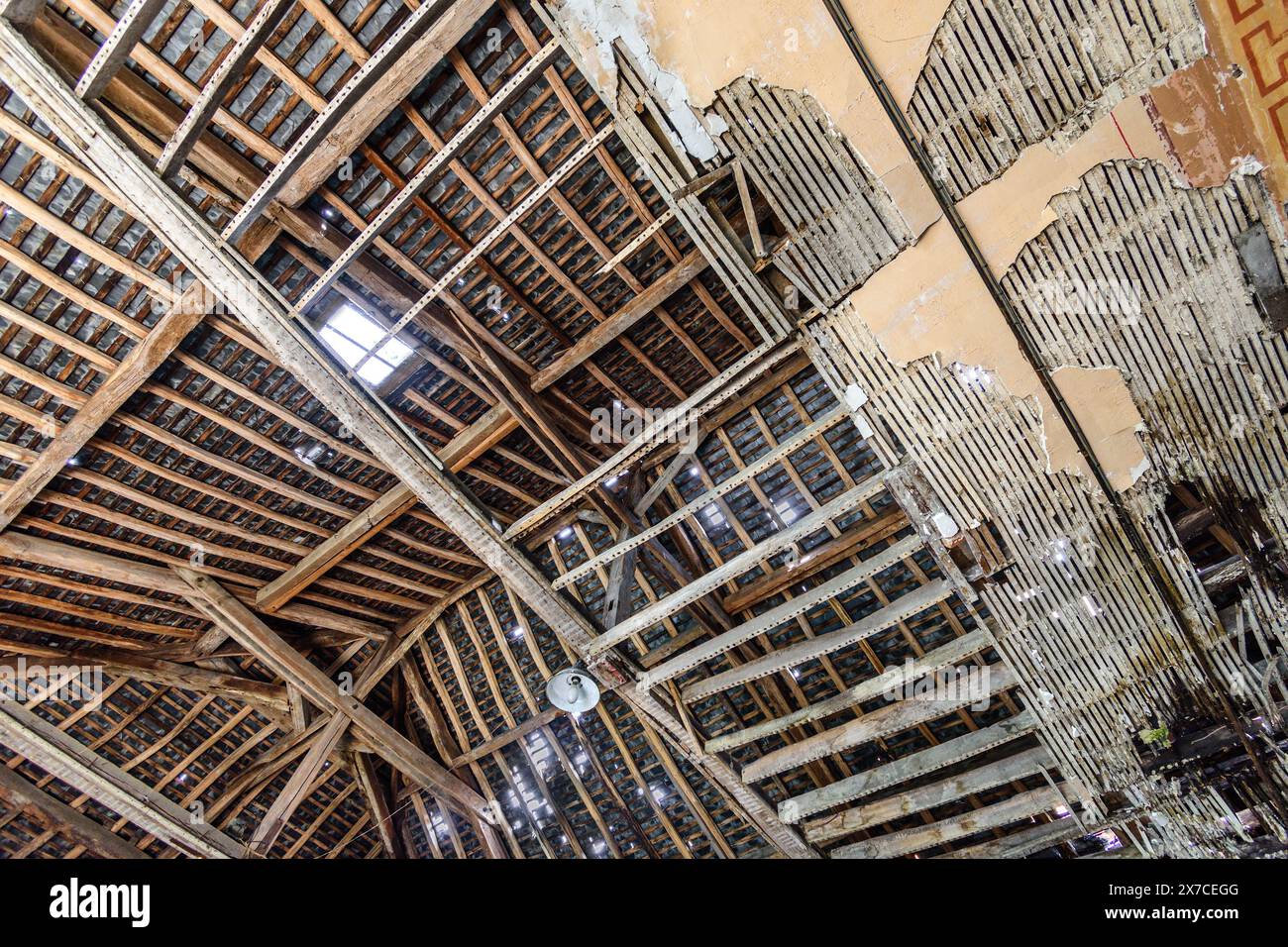 Collapsed ceiling revealing beams and laths in roof structure - Argenton-sur-Creuse, Indre (36), France. Stock Photo