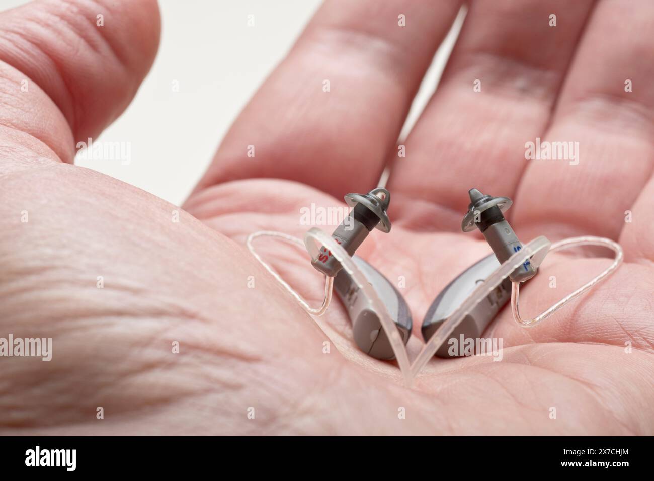 Close-up of a small discreet hearing aid in a male hand Stock Photo