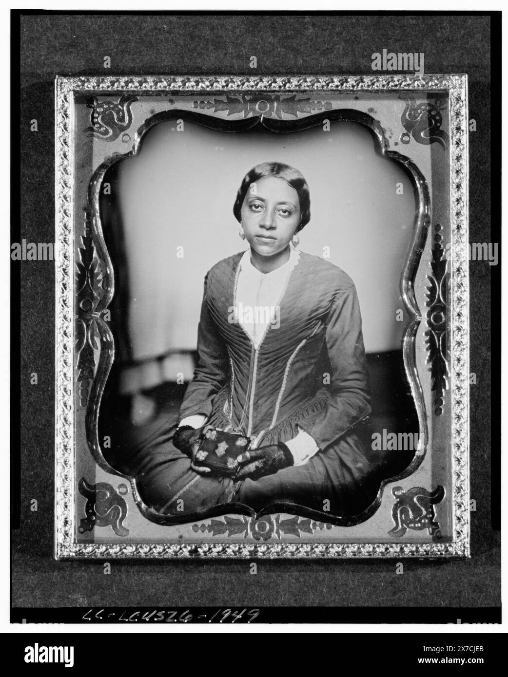 Woman, probably Sarah McGill Russwurm, sister of Urias Africanus McGill, three-quarter length portrait, facing front, holding daguerreotype case, Identification in: The Struggles of John Brown Russwurm / Winston James. New York : New York University Press, 2010, p. 81., Case: double case, red velvet with brass leaves at the corners; also houses DAG no. 1028., Was part of LOT 8554., Transfer; Manuscript Division., The American Colonization Society was organized in 1817 to resettle Afro-Americans in Liberia., Forms part of: American Colonization Society Records, 1792-1964 ,  Forms part of: Dague Stock Photo